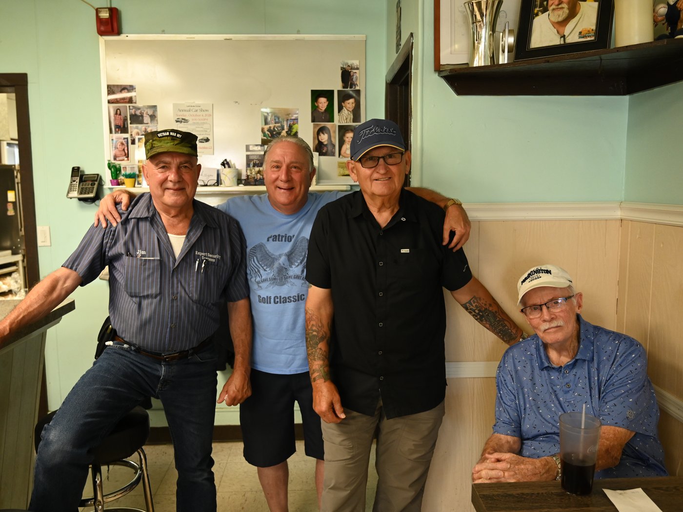 Four regulars at the counter inside Tom's Place